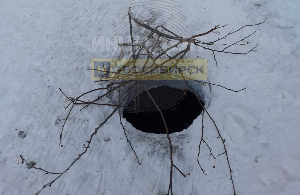 Почти безопасно: глубокий коллектор в центре Новосибирска прикрыли голыми ветками