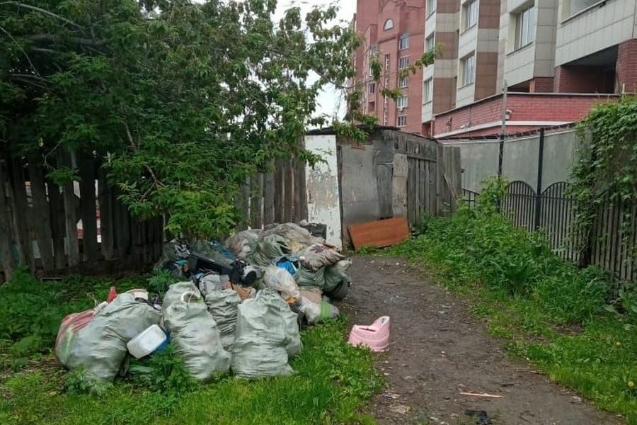 Женщину заставили убрать свалку на участке рядом с высотками в Новосибирске