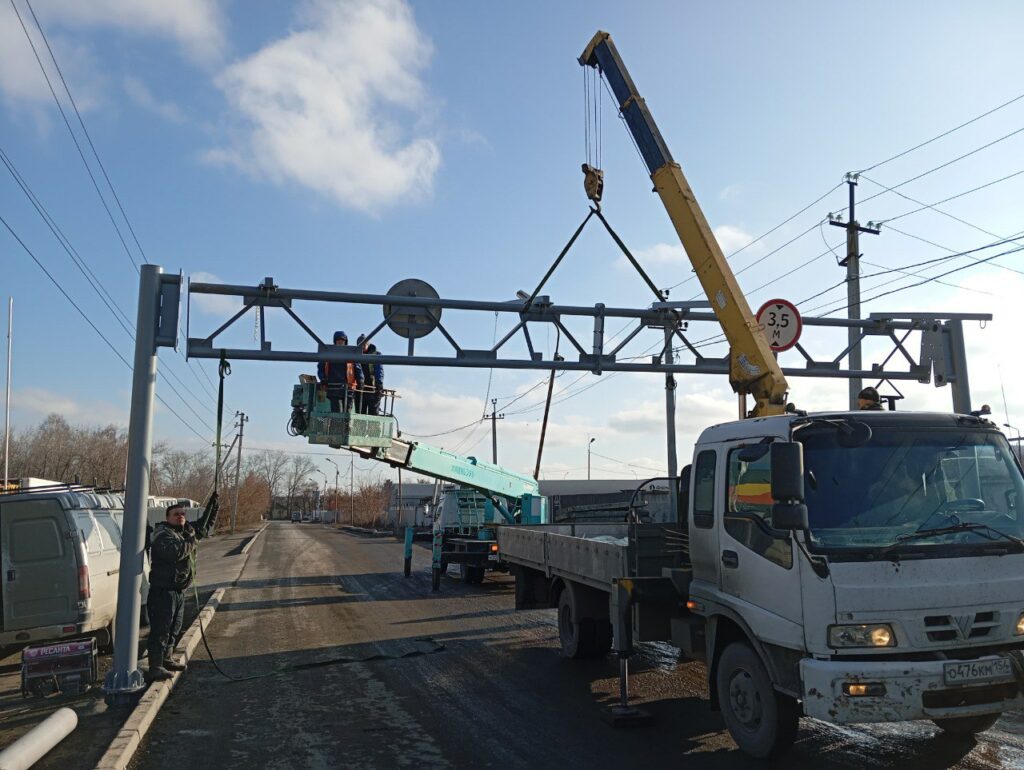 Фуры объезжают ограничительную рамку на Малыгина через кладбище