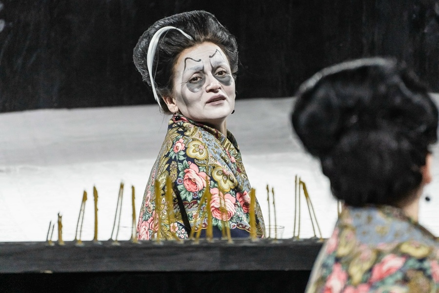 Угольно-черные волосы Маменьки, стоящие как тиара Нефертити, прошитые одинокой молнией белой прядки — ироничный оммаж к американской индустрии ужаса